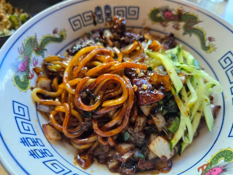 Ganjajang noodles with the poached egg yolk broken open