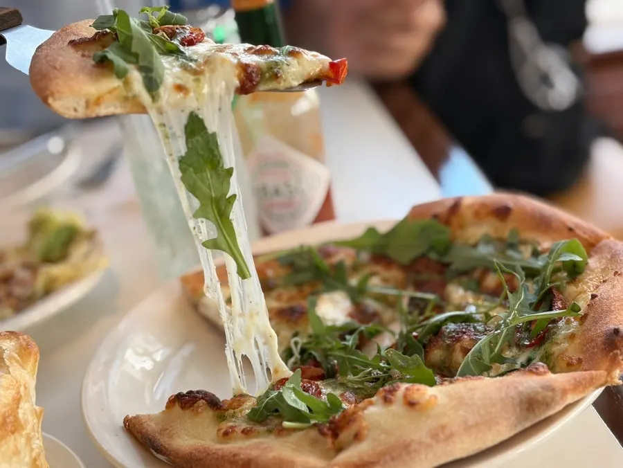 A slice of pizza with stretching cheese