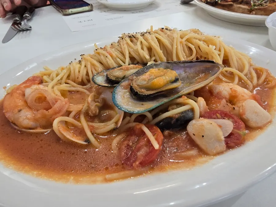 Seafood pasta topped with green mussels