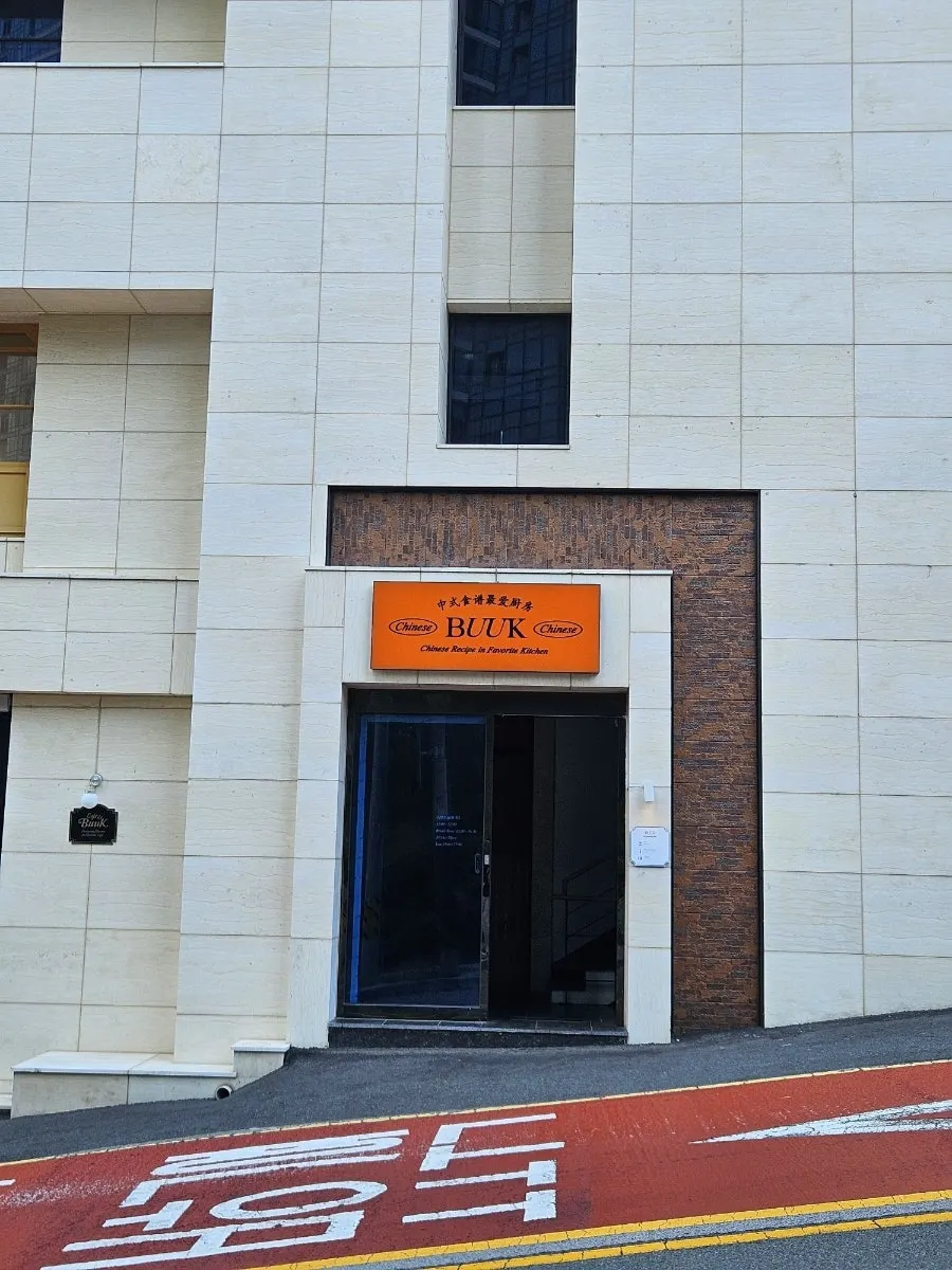Orange BUUK Chinese sign and brown brick entrance