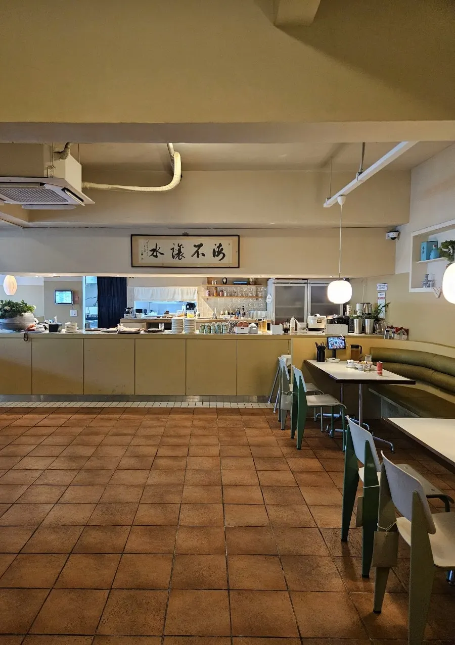 Restaurant interior with olive-green walls and terracotta tile floors