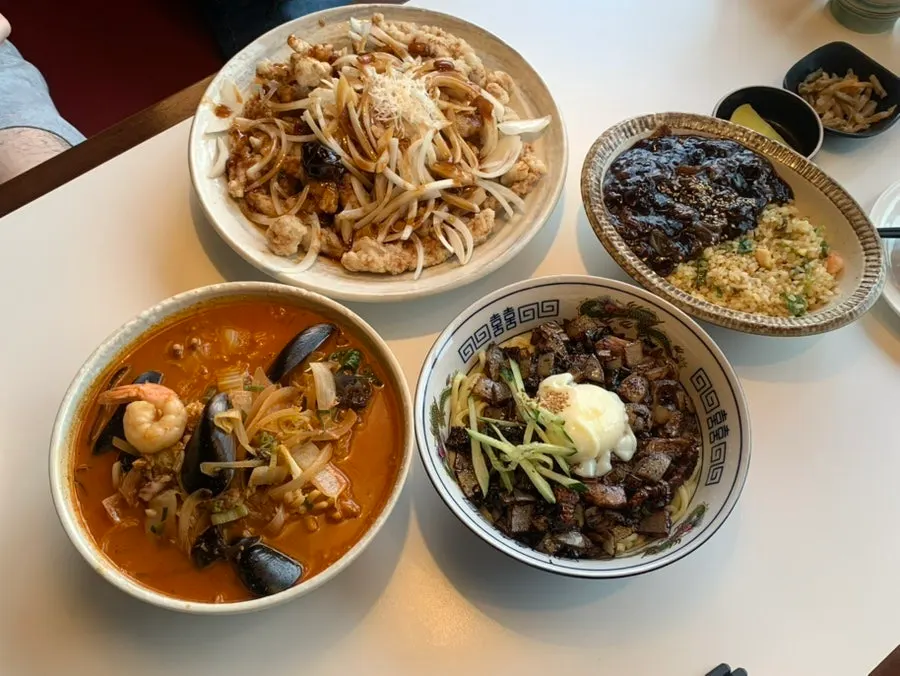 A table spread with black vinegar pork sirloin tangsuyuk and jjamppong