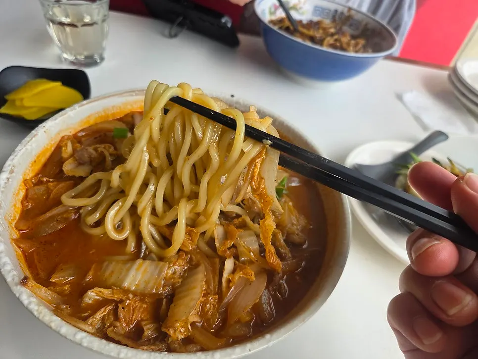 Table set with jjajangmyeon, jjamppong, and tangsuyuk