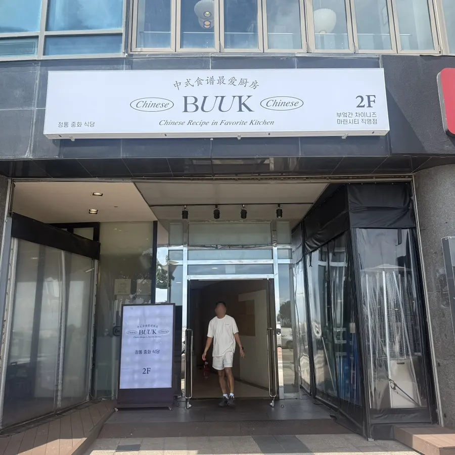 Entrance of the Suybeon Choego Pork Gukbap building with signage for Bueokgan Chinese on the 2nd floor