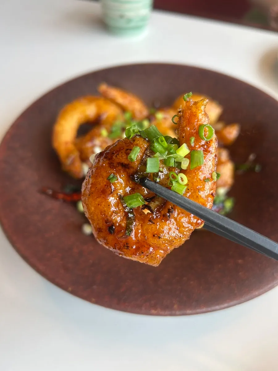 Close-up of kkanpung shrimp topped with fried peppers and peanuts