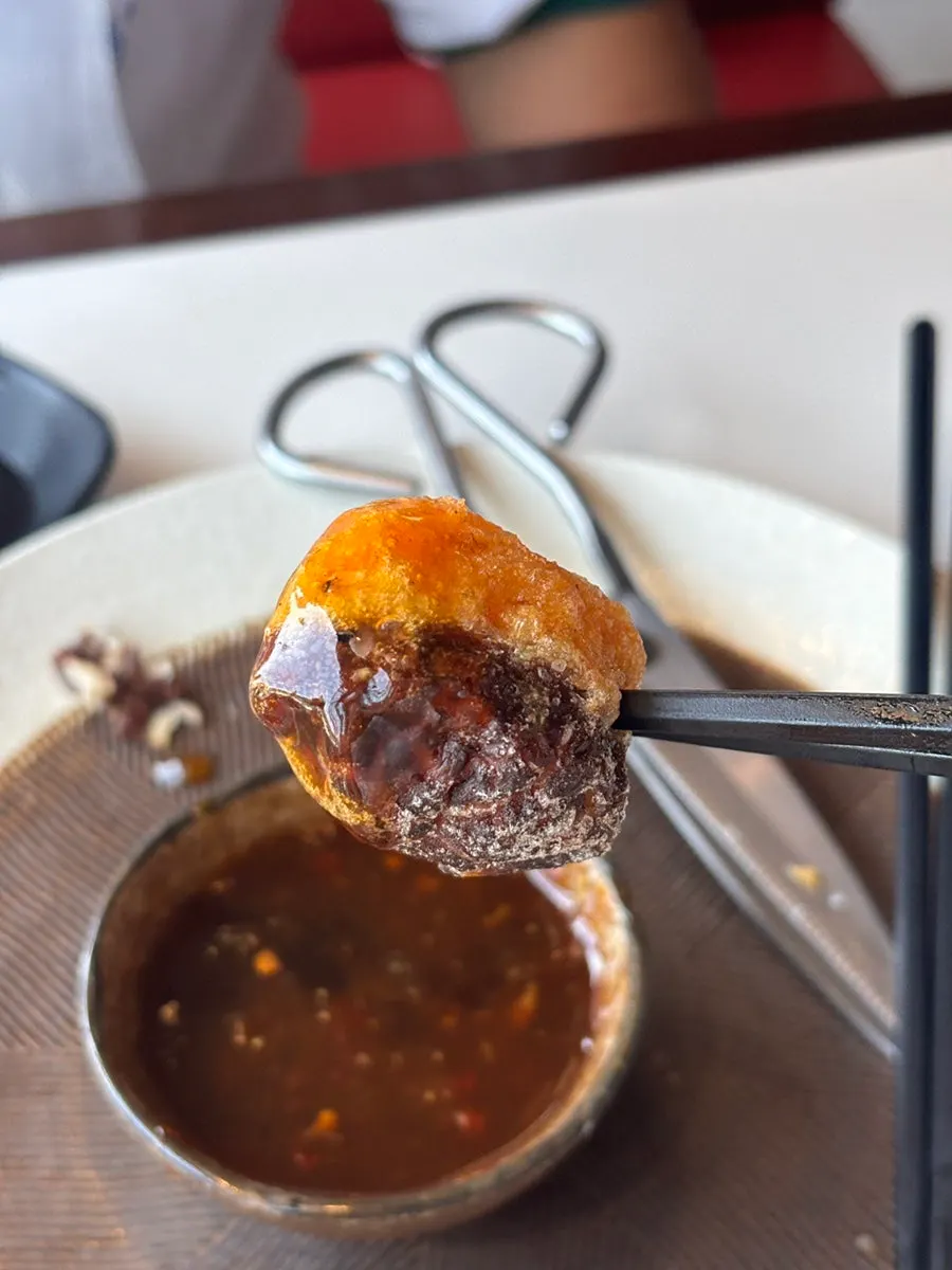 A piece of pyogosha dipped in sauce
