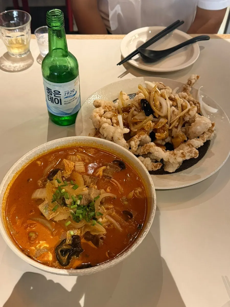 Table set with woo samgyeop jjamppong and black vinegar tenderloin tangsuyuk