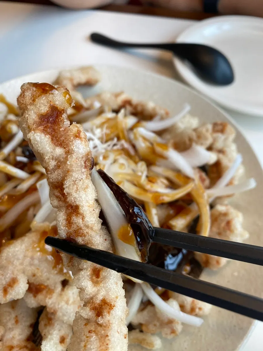 Picking up a piece of black vinegar tangsuyuk with chopsticks