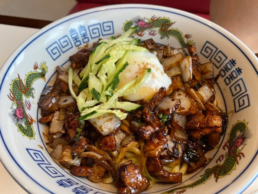 A bowl of five-layer pork ganjajang topped with a poached egg