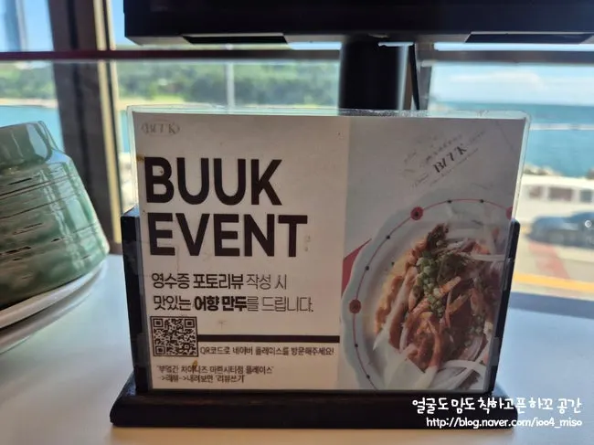 Sign about free eohyang mandu with a receipt photo review