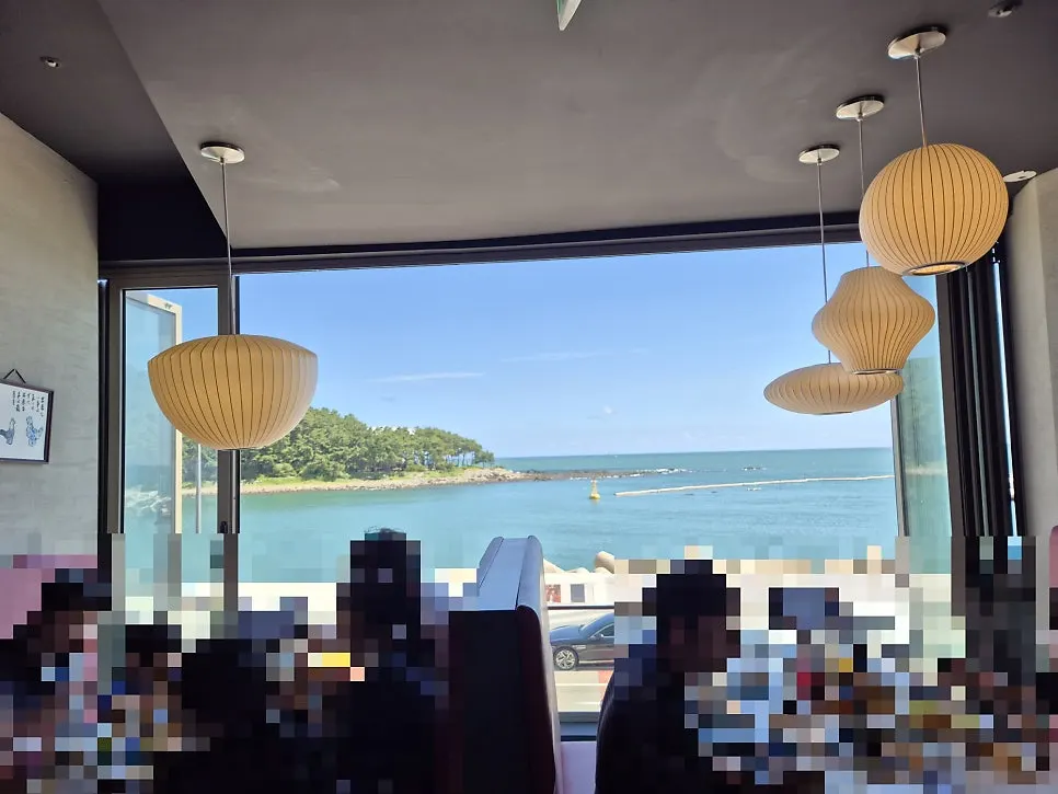 Light fixture swaying in the wind with the ocean view from the window