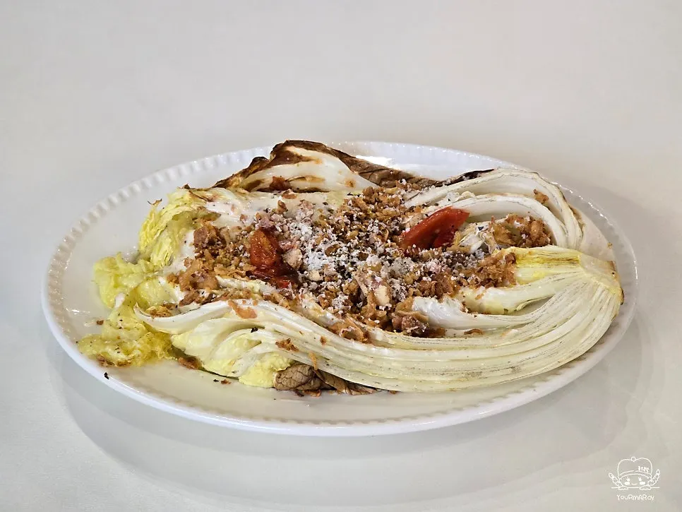 Napa cabbage Caesar salad topped with cheese and bacon chips