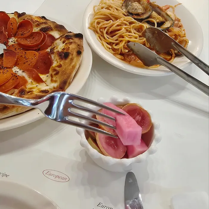 Pickles served alongside the pizza and pasta