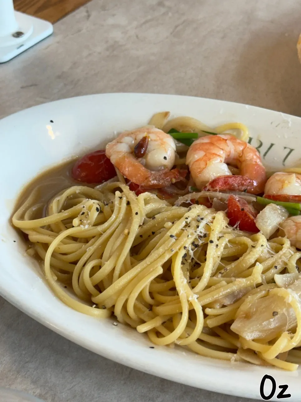 Close-up of oil pasta topped with large shrimp