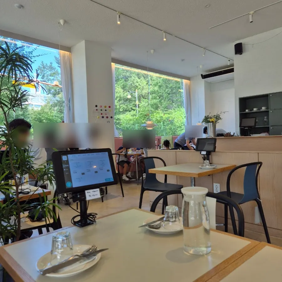Seats by the large window overlooking the park's greenery
