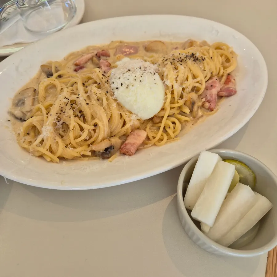 A plate of carbonara topped with poached egg