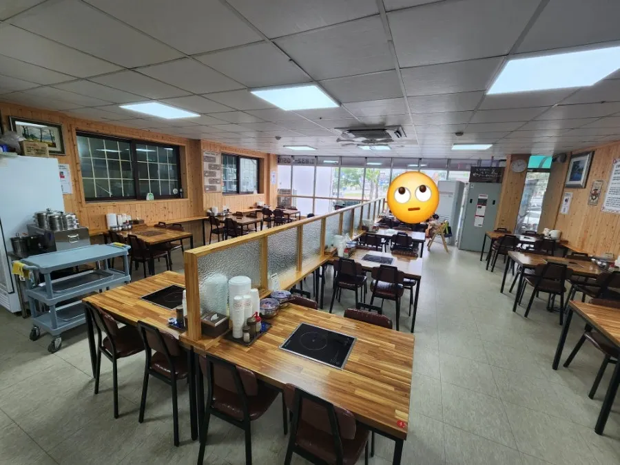 나무 벤치와 흑백사진 촬영 기계가 있는 대기 공간