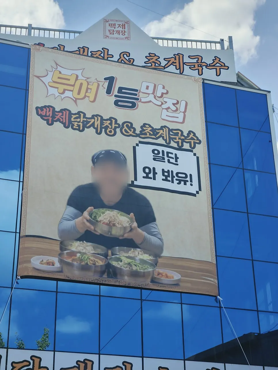 Storefront sign featuring the owner's face and name