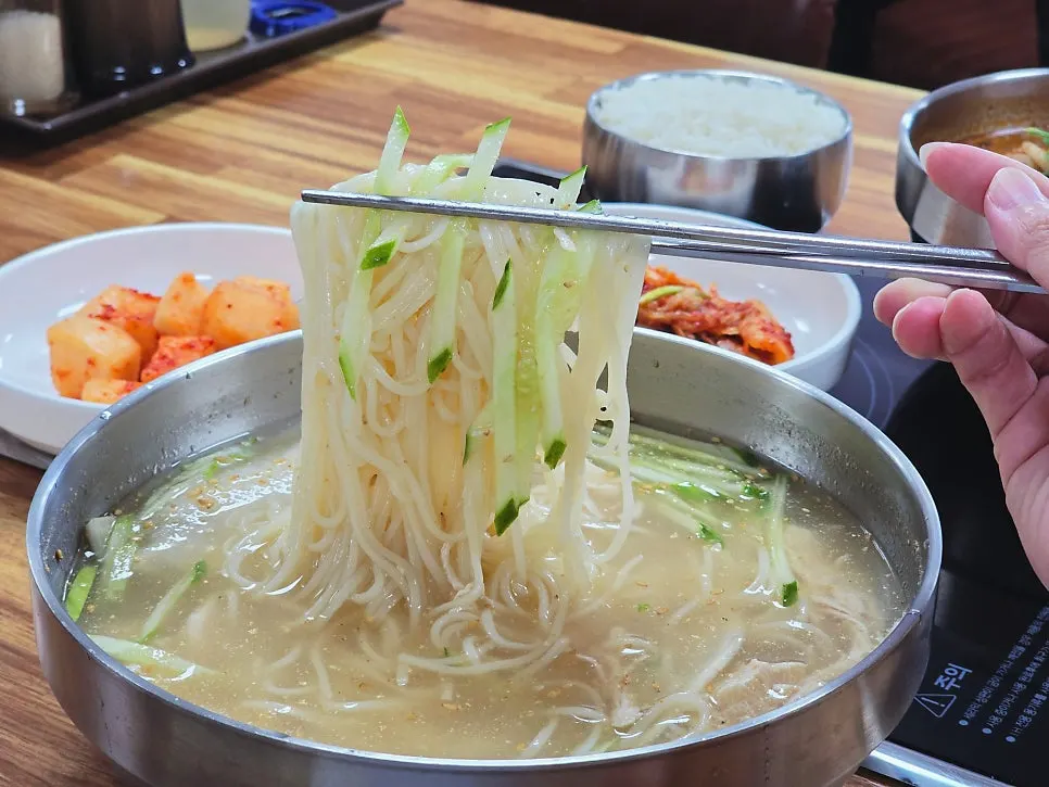 Close-up of chogyeguksu piled with chicken and noodles