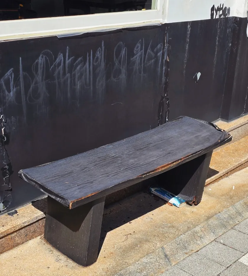 The word 'Baiden' written on the wall in place of a sign, with the entrance bench
