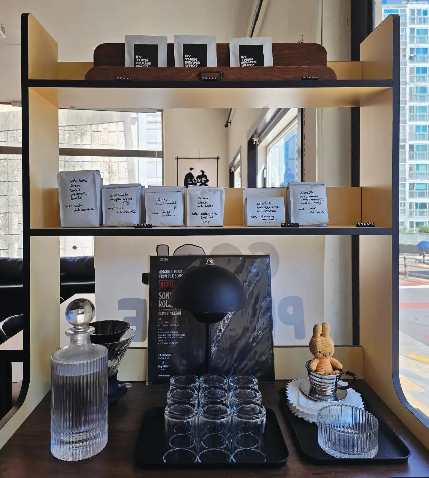 Water and cups at the entrance, with coffee on the shelf
