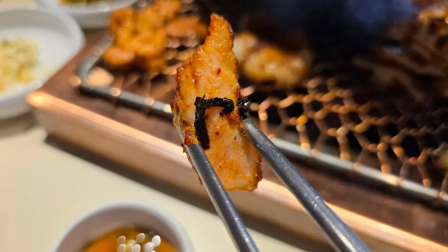 Fully cooked pieces pushed to the edge of the grill