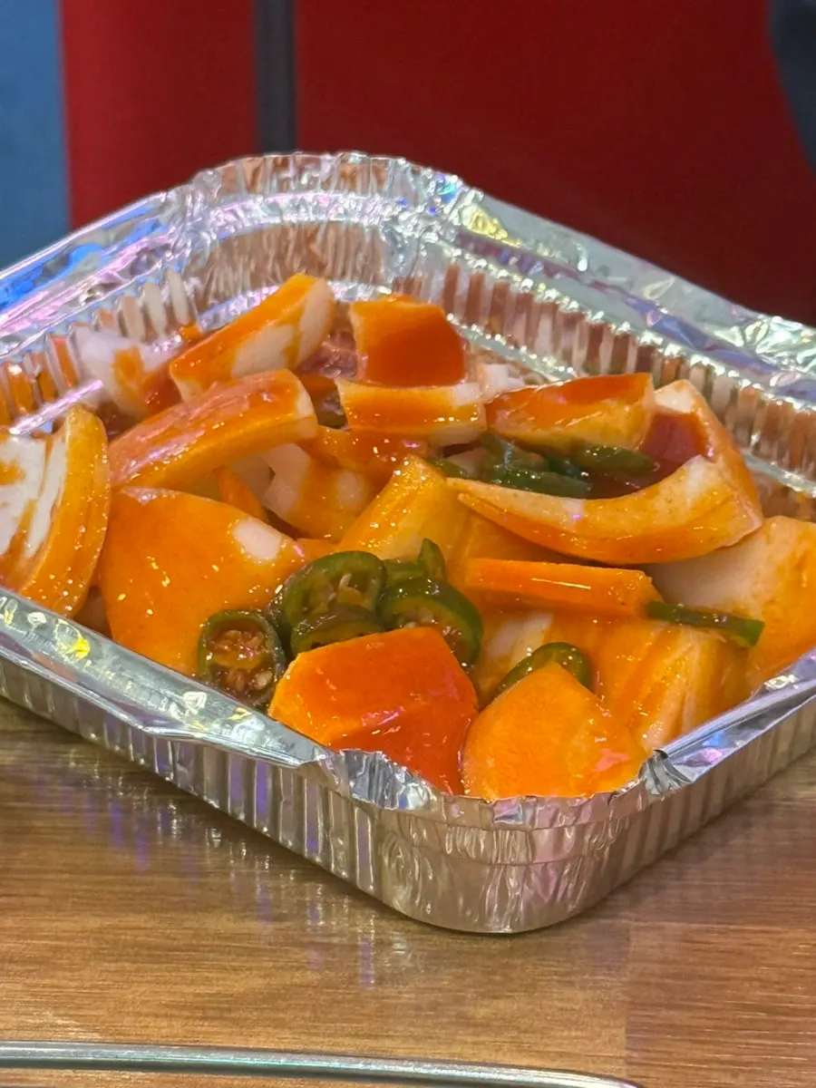 Tteokbokki and mozzarella cheese in a foil tray