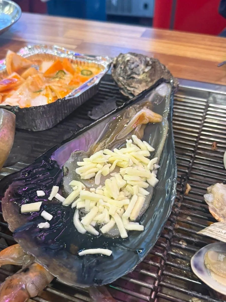 Grilled clam platter tray topped with abalone and shrimp