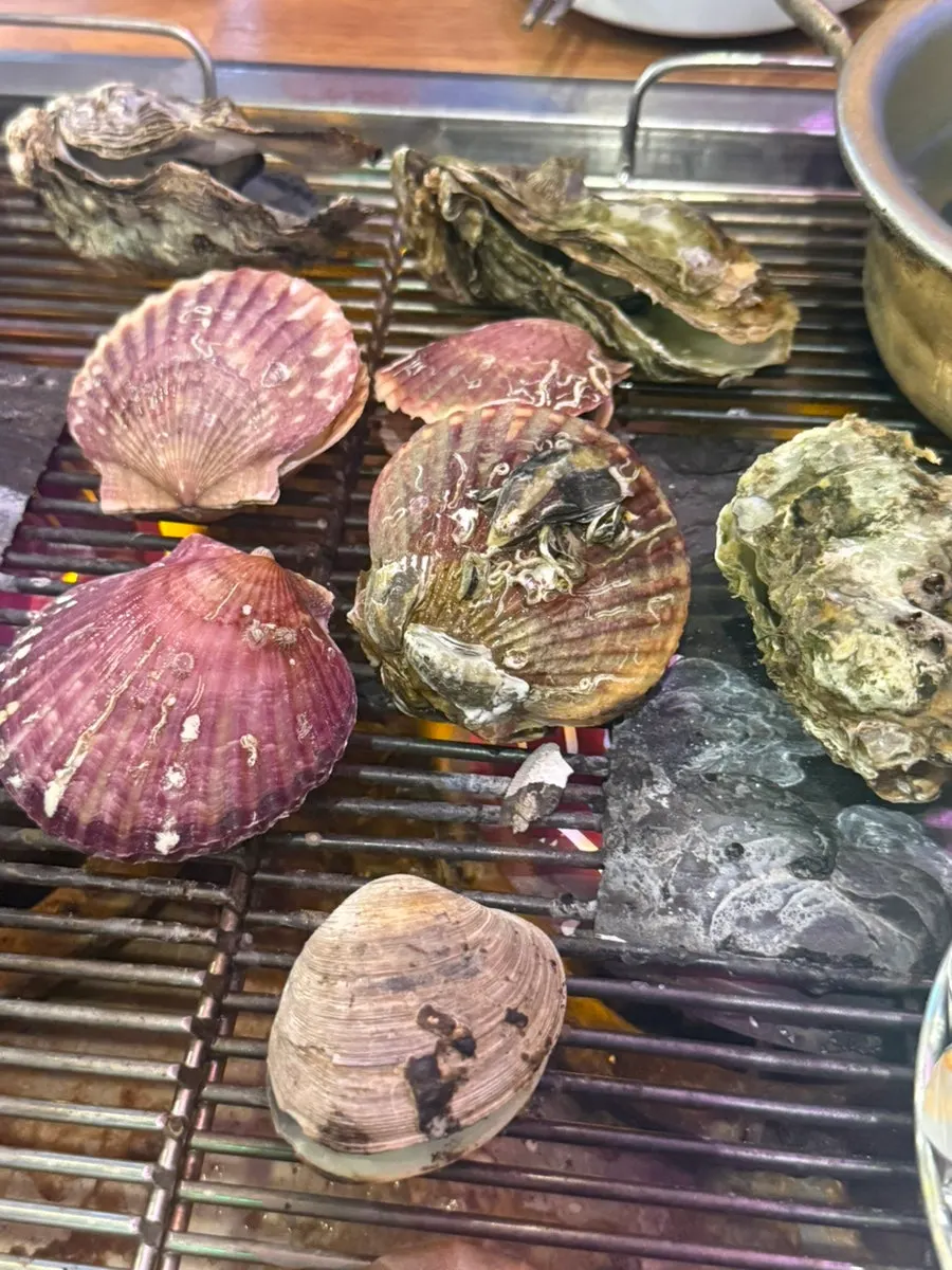 Scallops and flat sail clams cooking on the grill