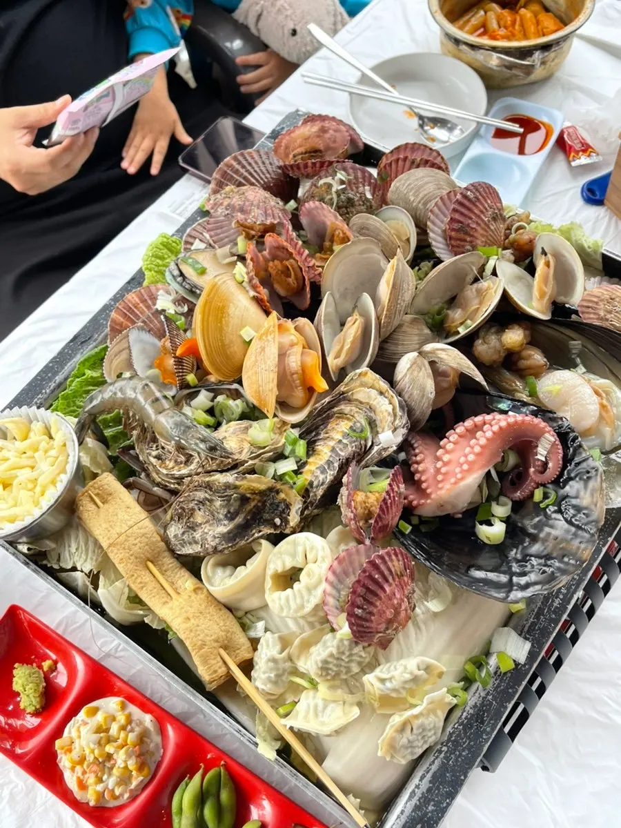 Clam steamer with broth cooking on the burner