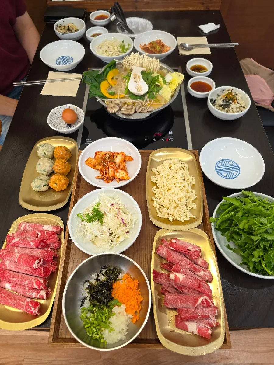 긴 테이블 가득 차려진 만두전골 한상차림