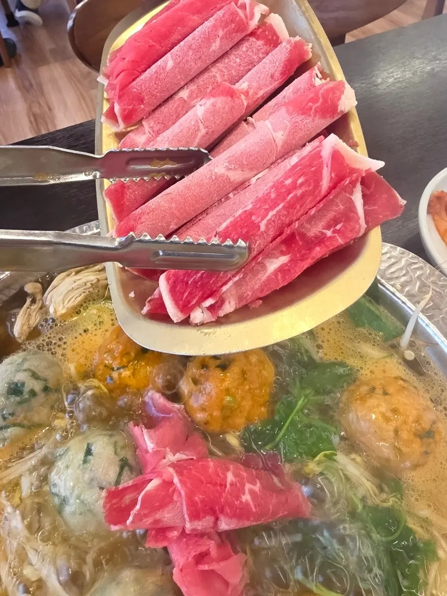 Table setting with side dishes and fresh-cut salad at Onjeongban
