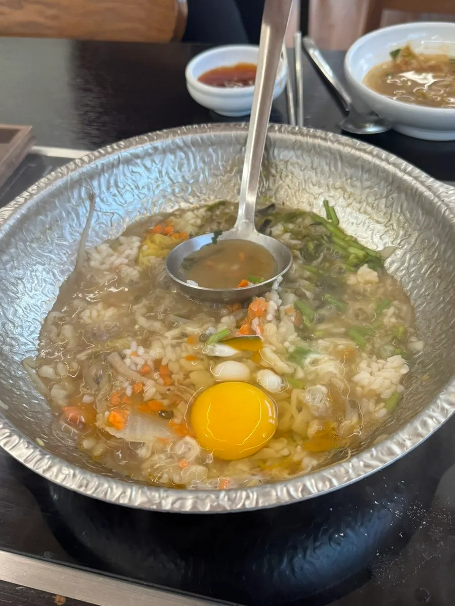 A bite of kalguksu noodles topped with geotjeori