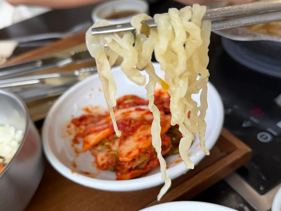 Fresh kalguksu noodles added into the hot pot broth