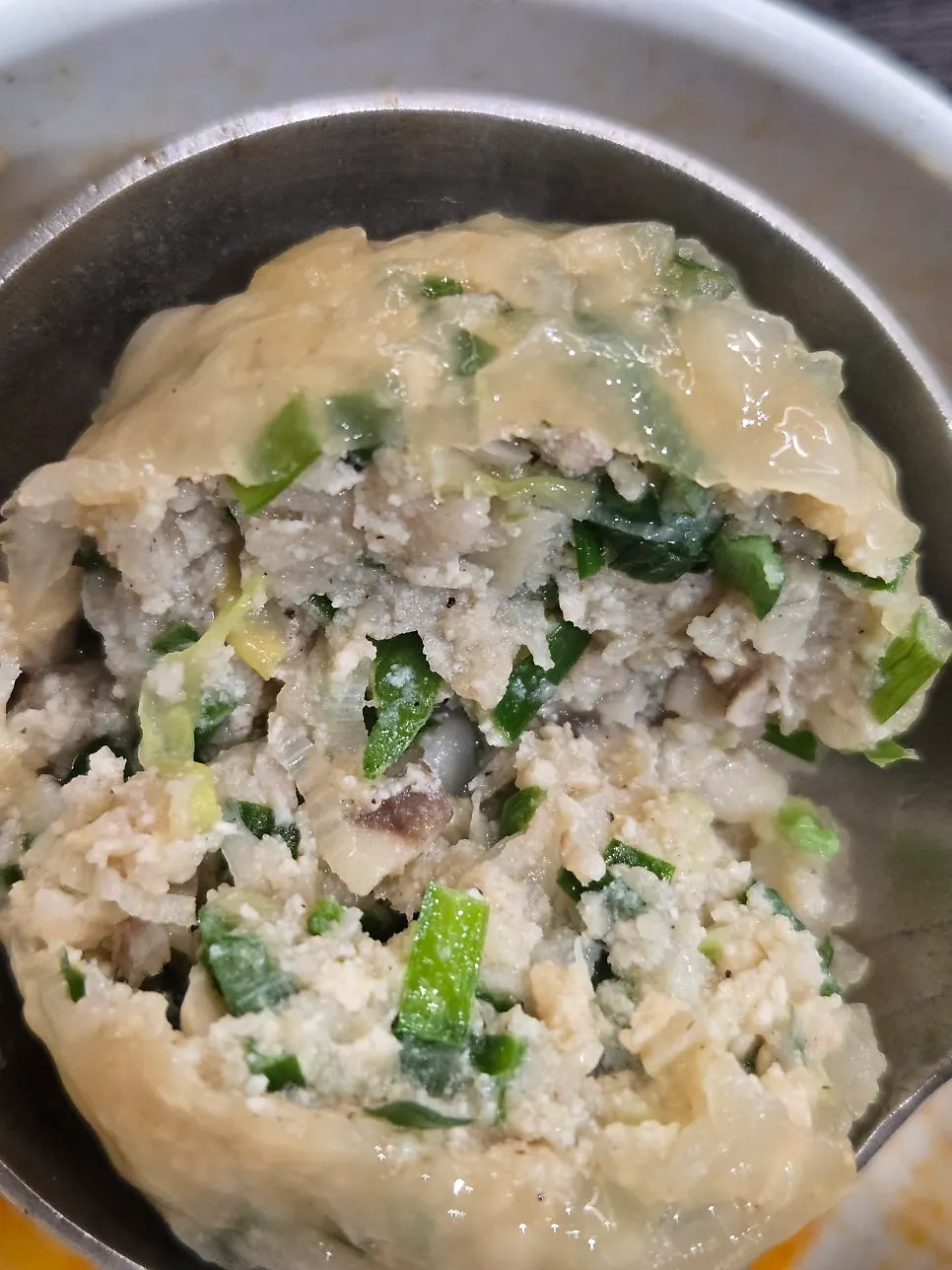 Half kimchi, half meat rolled dumplings added to broth