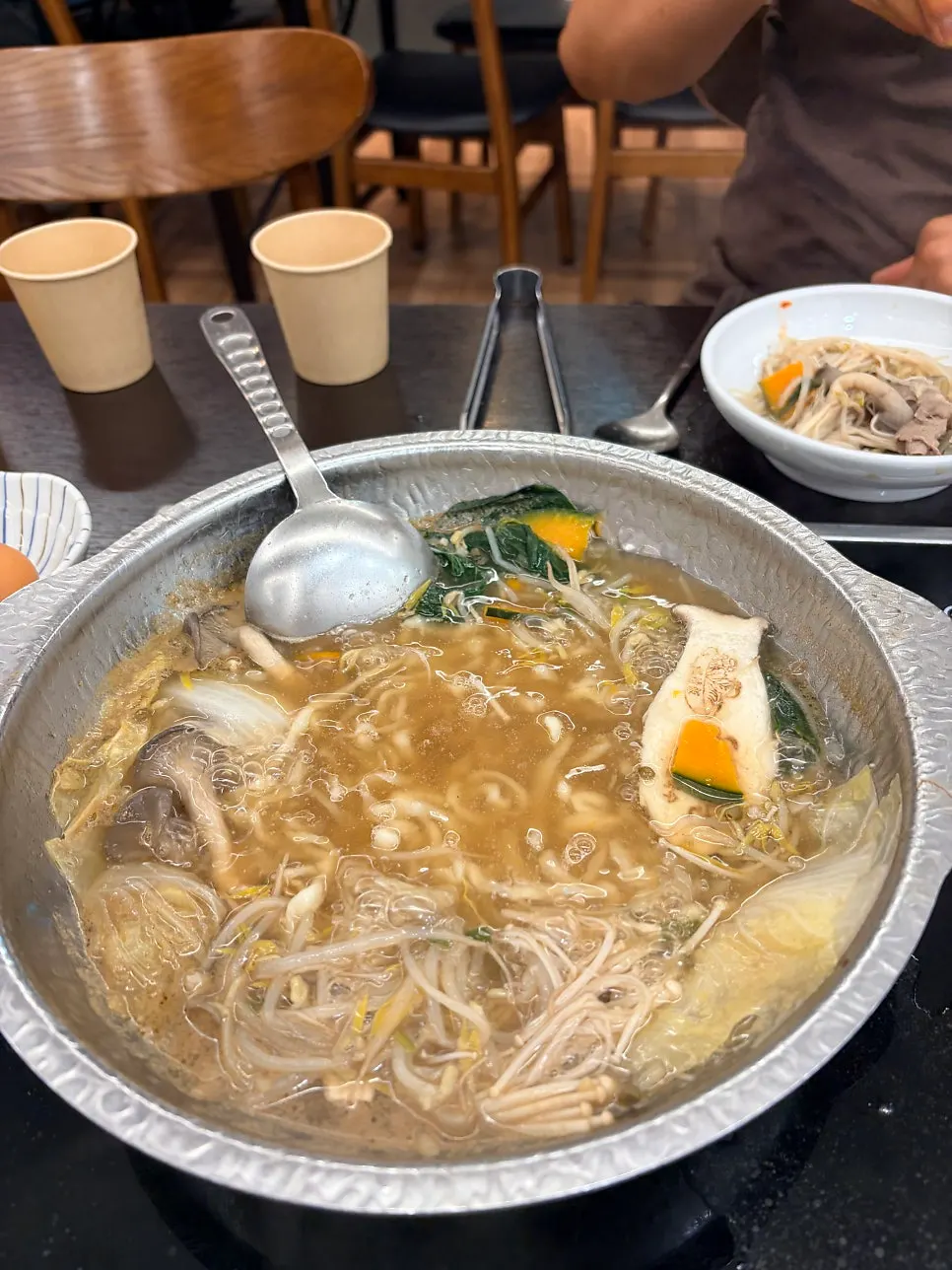 Kalguksu noodles cooking in the enriched broth