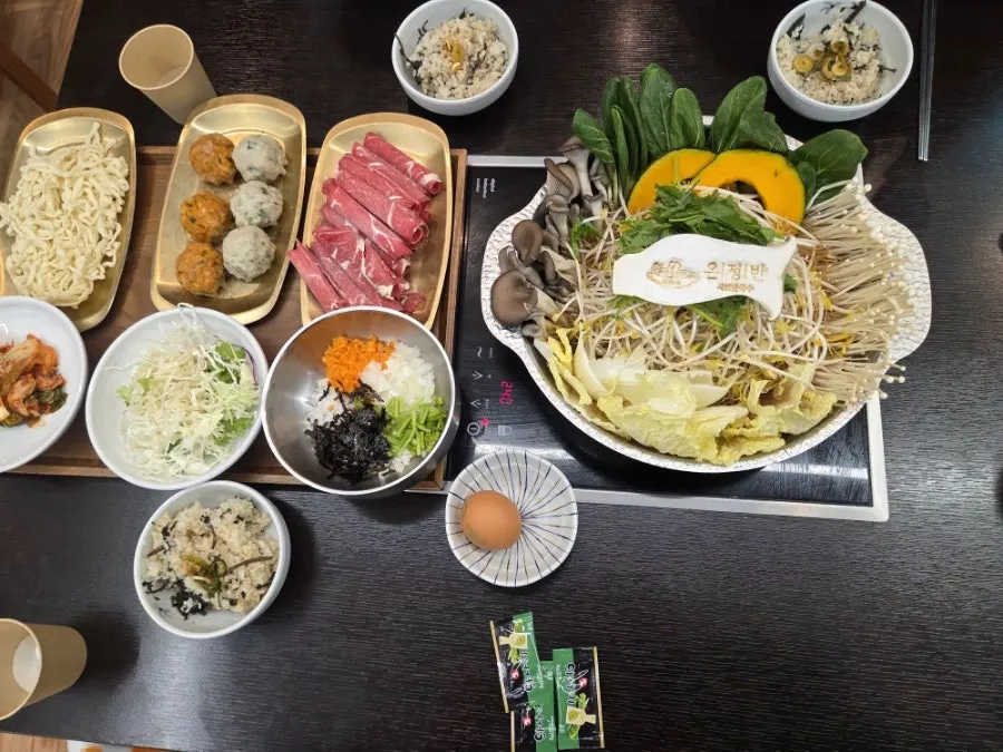 칼국수와 죽 재료가 포함된 굴림만두전골 한상