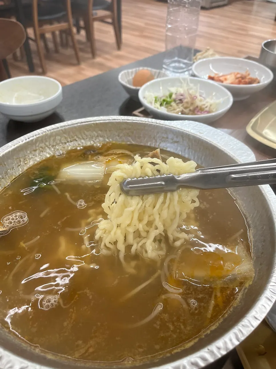 Kalguksu noodles boiling in the spicy broth