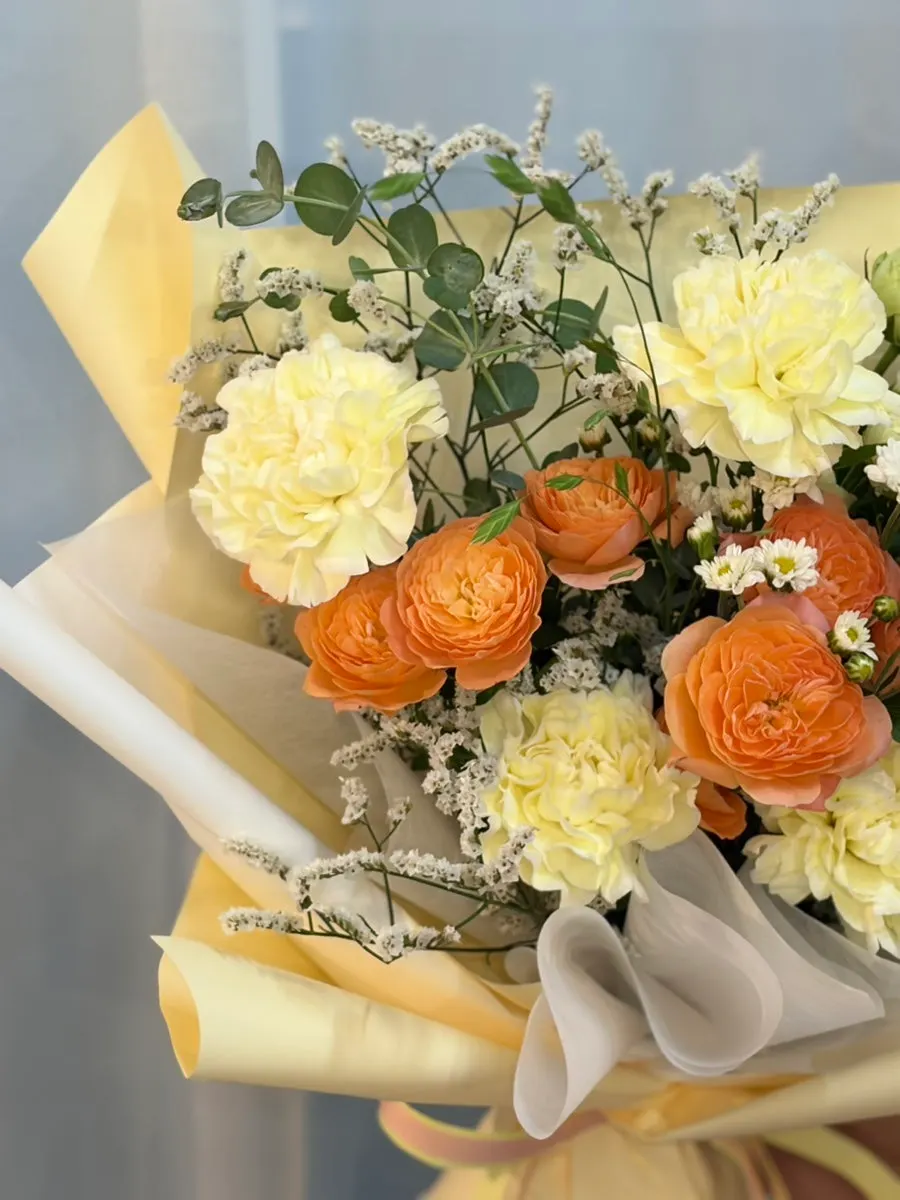Close-up of the yellow, peach, and white bouquet