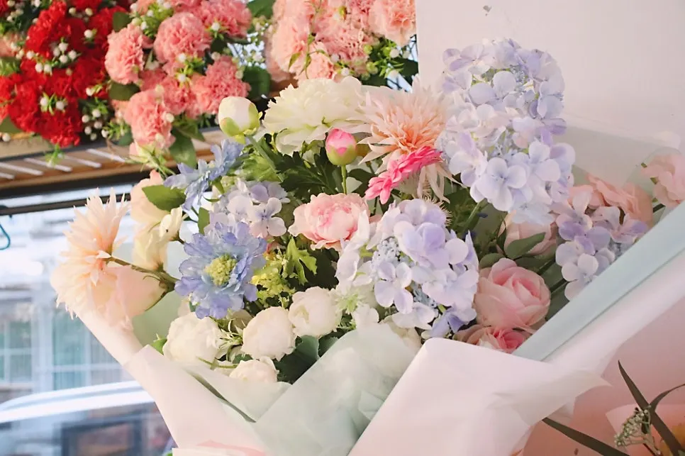 Artificial flower bouquets displayed next to the potted plants
