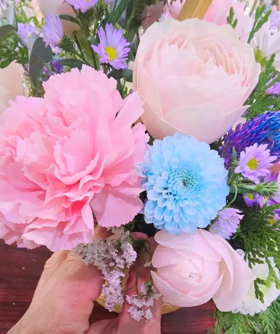 Close-up of yellow mini roses and lisianthus in the basket