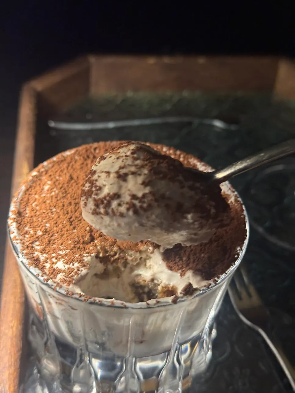 A spoonful of tiramisu lifted from the dish