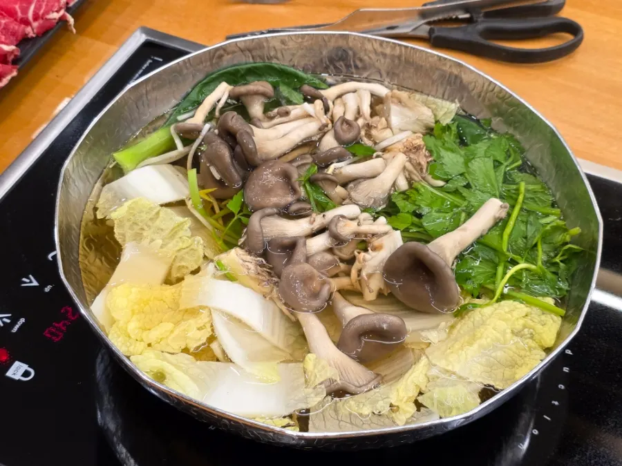 Pot of clear shabu broth starting to boil