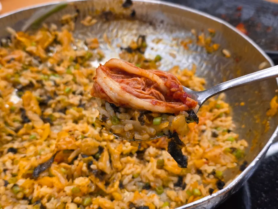 A spoonful of fried rice topped with kimchi