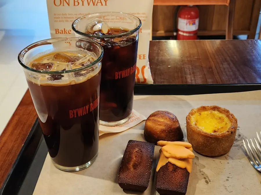 A cup of coffee placed next to dessert