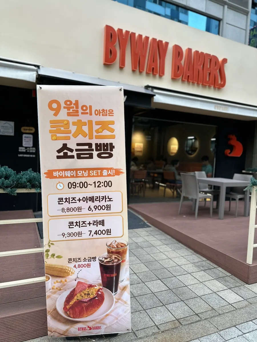 Exterior of Byway Bakers Balsan Station with orange lettering on beige background