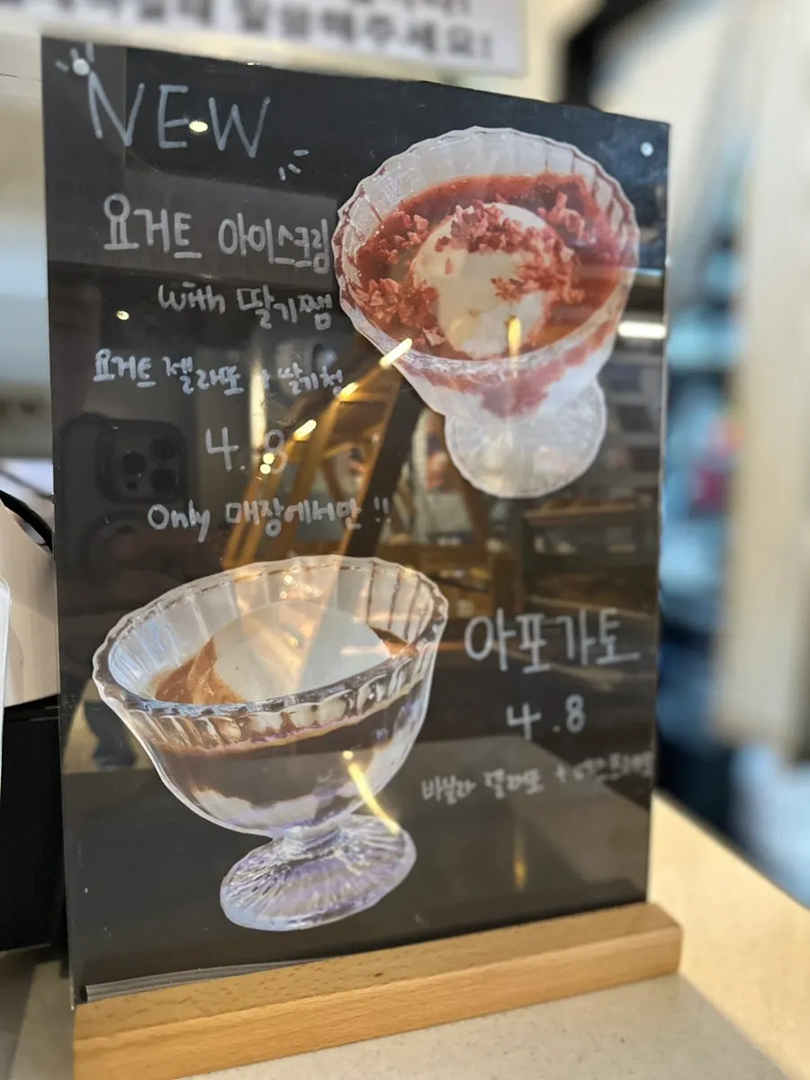 Drink menu board listing coffee, tea, and ade