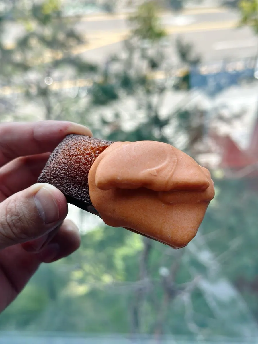 Cross-section of egg cheese financier with cookie bits inside