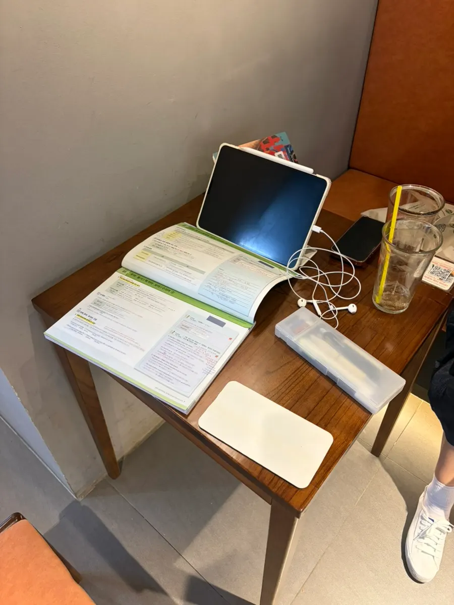 Table with iced americano and an open book