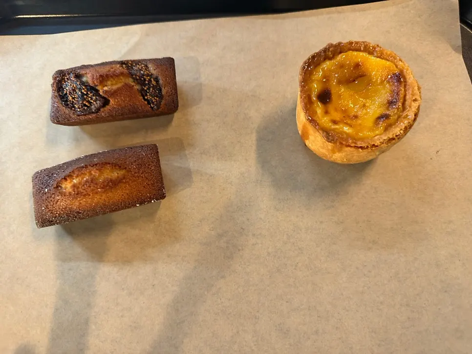 커피와 함께 놓인 휘낭시에 두 개